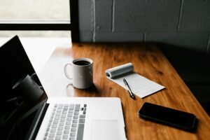 Laptop and notebook on a desk, ready for writing